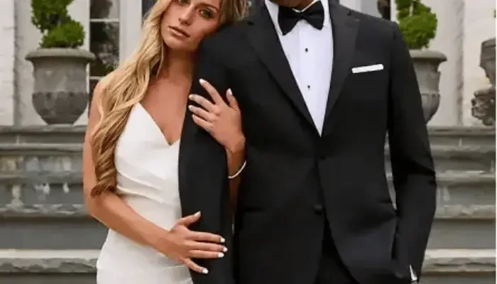 Bride and groom posing outdoors, with the bride wearing a white wedding dress and the groom wearing a black tuxedo with a bow tie.