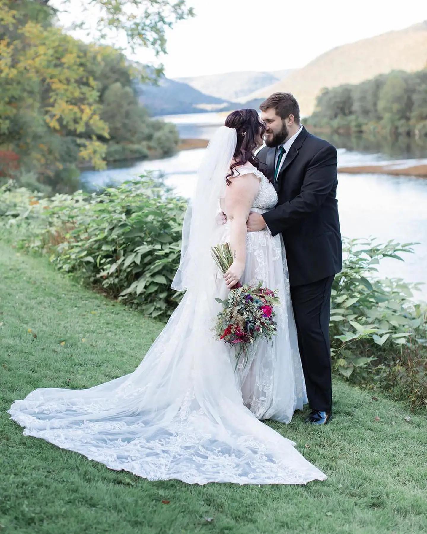 Сouple wearing a white gown and a black suit on the grass