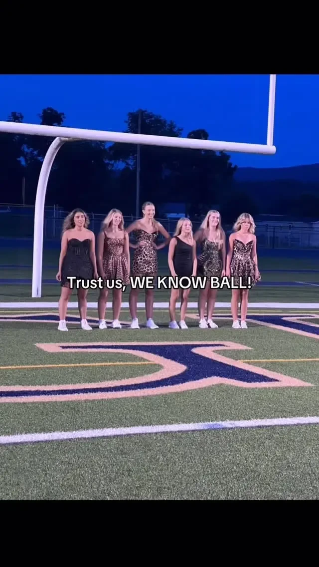 models wearing homecoming dresses on a football field